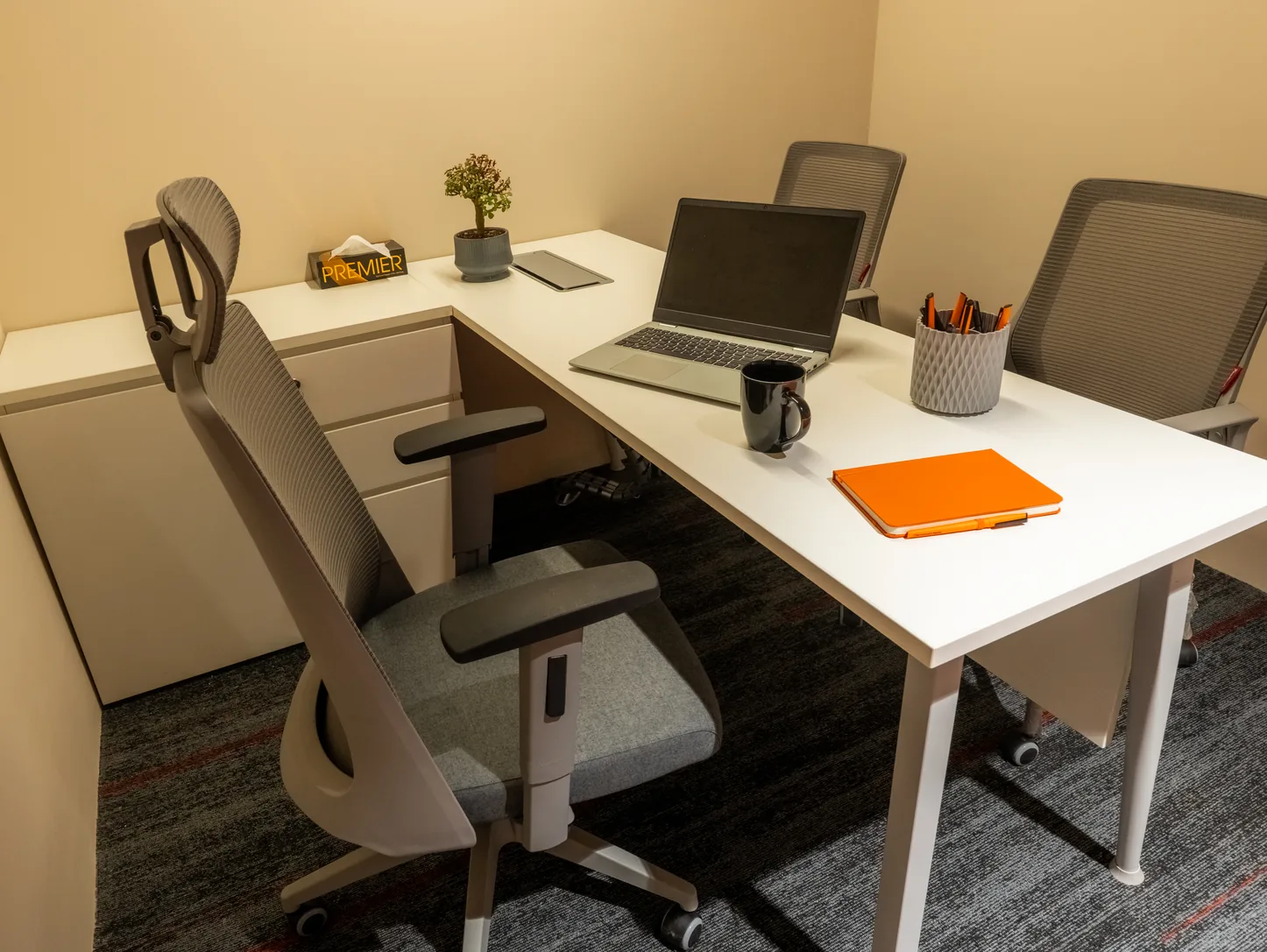Bitpod manager cabin with a white desk, neatly aligned guest chairs and large windows